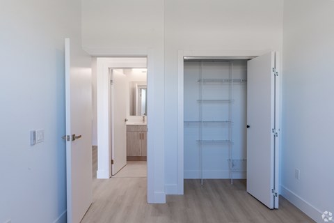 A white hallway with a door on the left and a door on the right.