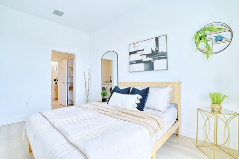 A bedroom with a large bed and a mirror on the wall.