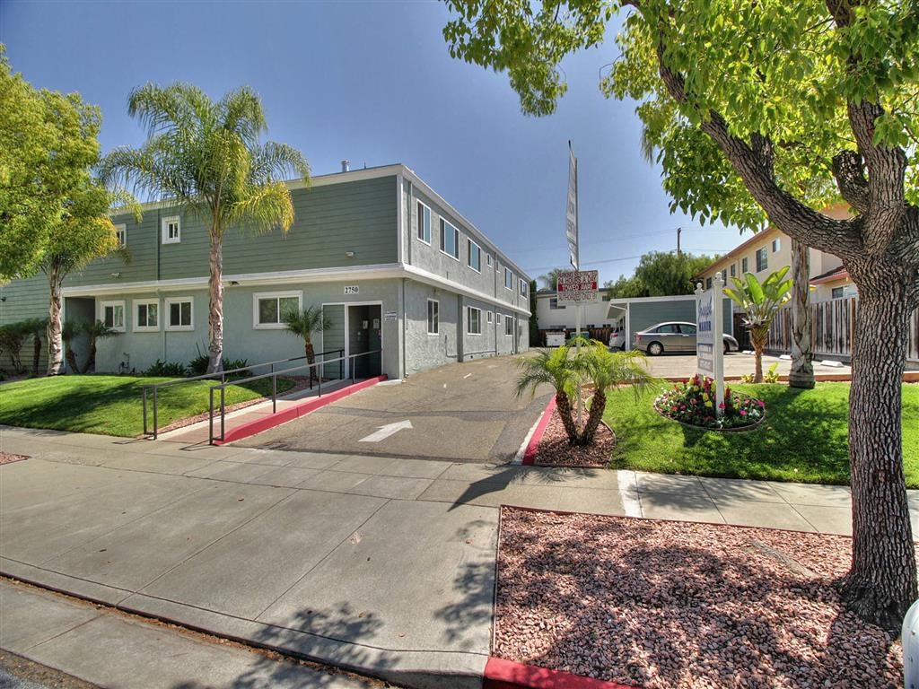 A building with a green roof and a red and white striped curb in front of it.