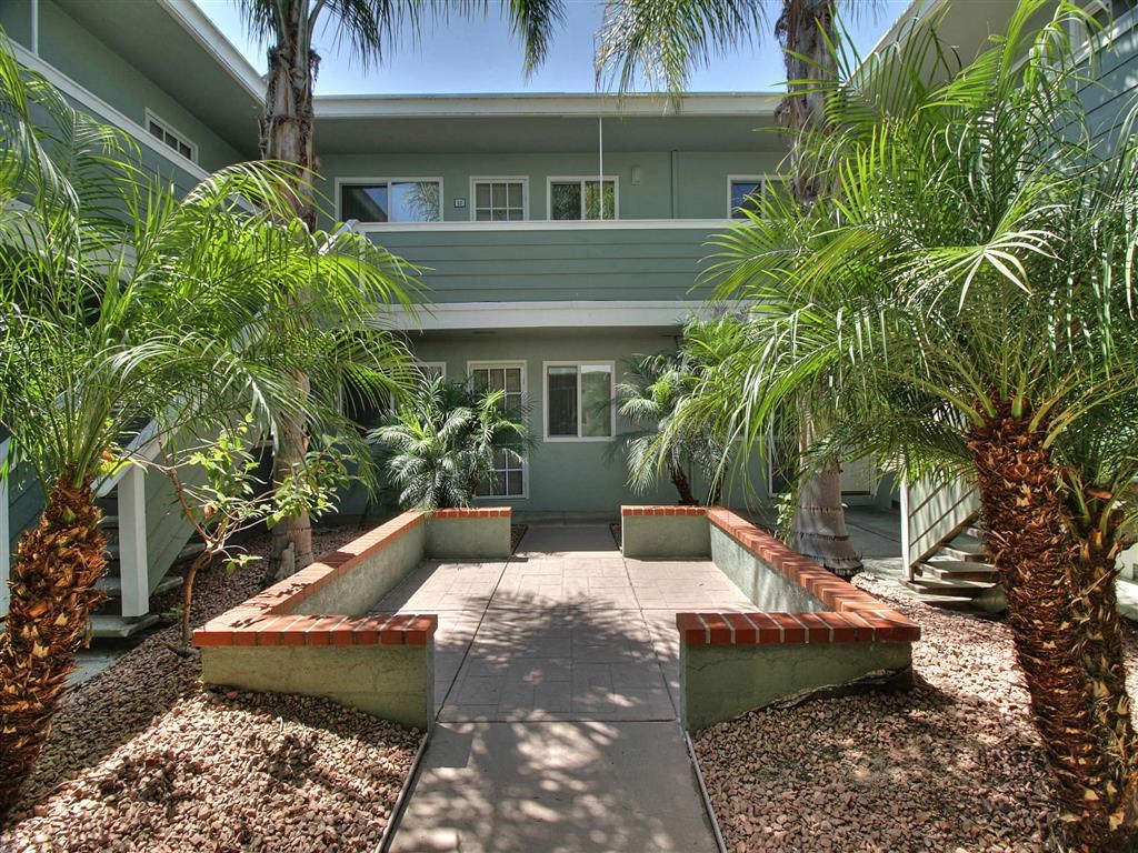 A courtyard with a concrete floor and a building in the background.