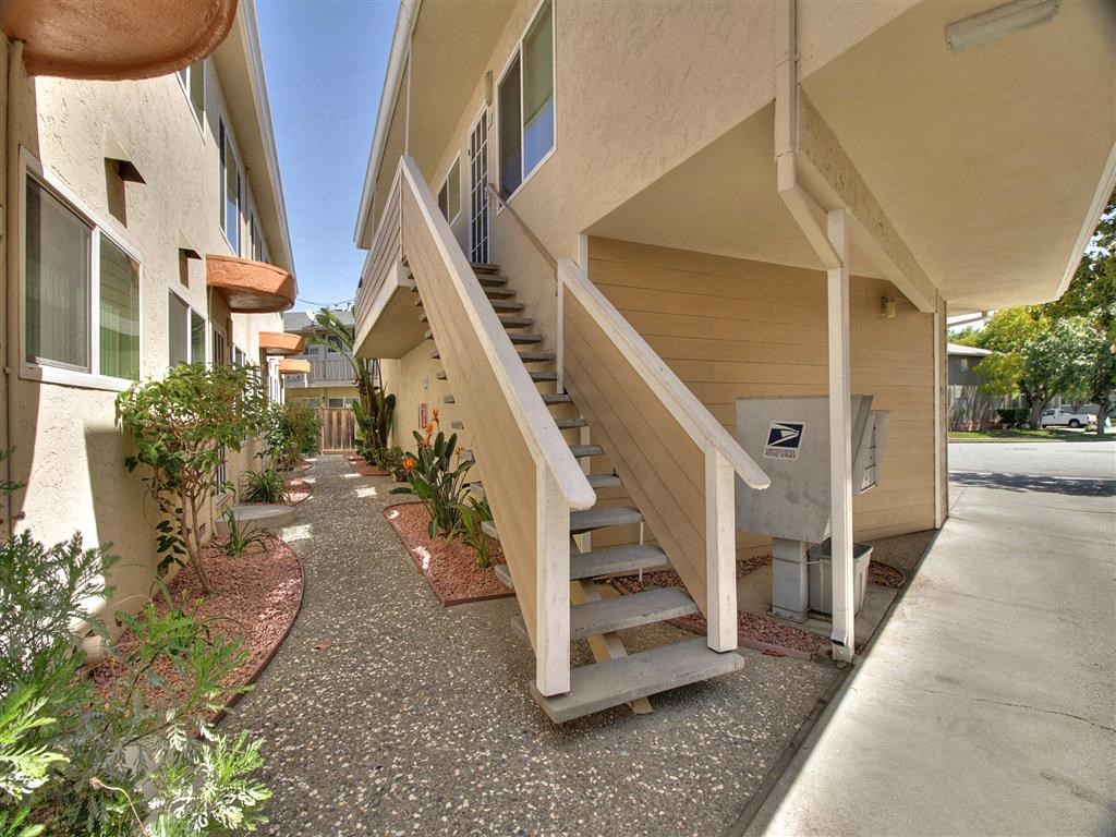 A concrete pathway leads to a mailbox on a residential building.