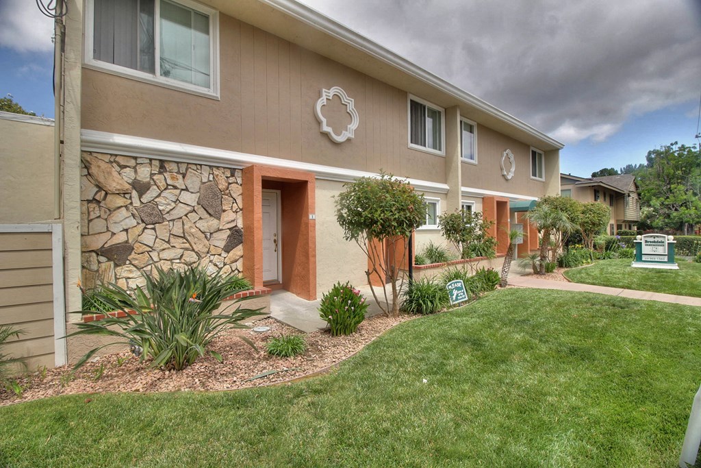 A row of houses with a green sign in front.
