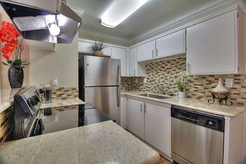 a kitchen with stainless steel appliances and white cabinets