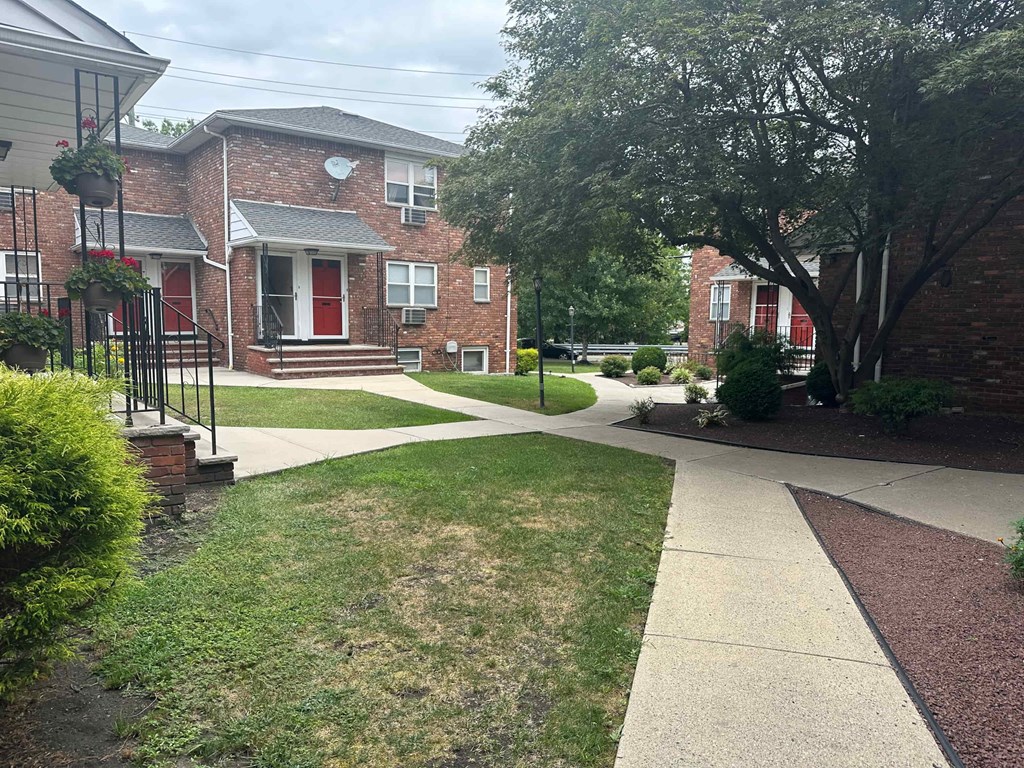 A residential area with a brick house and a red door.