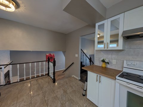 A kitchen with white cabinets and a black stove top oven.
