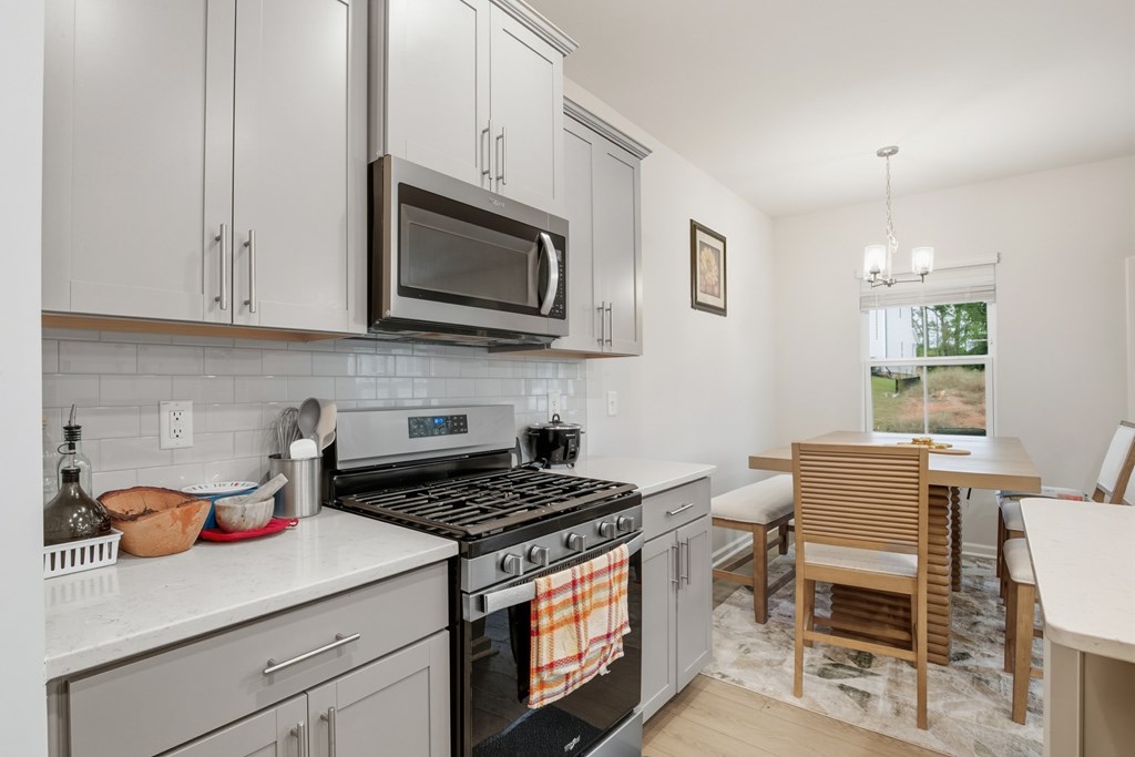 A kitchen with a stove top oven and a microwave above it.