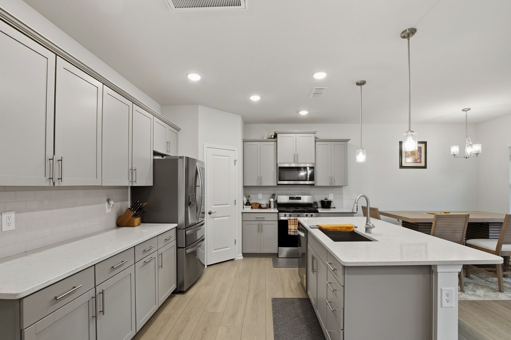 A modern kitchen with white cabinets and a large island.