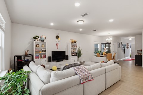 A living room with a white couch and a television.