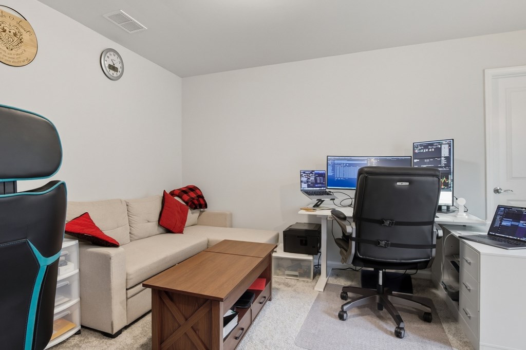 A room with a couch, chair, and computer desk.