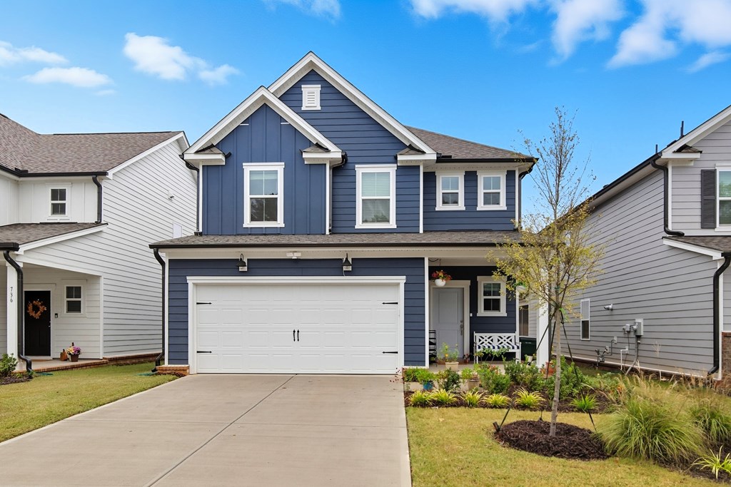 A blue house with a white garage door in front.