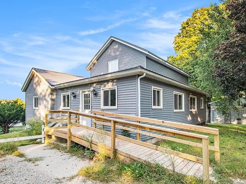 A house with a grey exterior and a wooden deck.