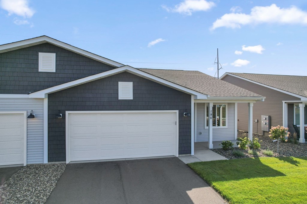 A house with a grey garage door and a brown roof.