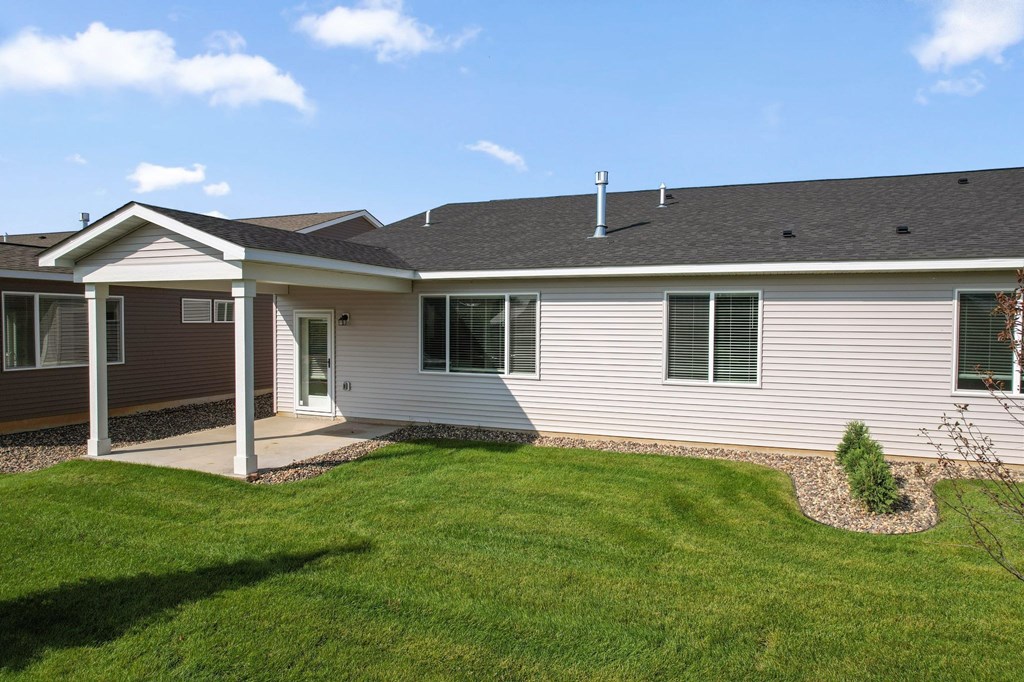 A house with a brown roof and a white porch.