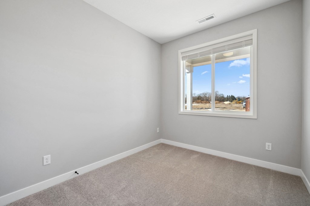 A room with a window showing a view of trees and a blue sky.