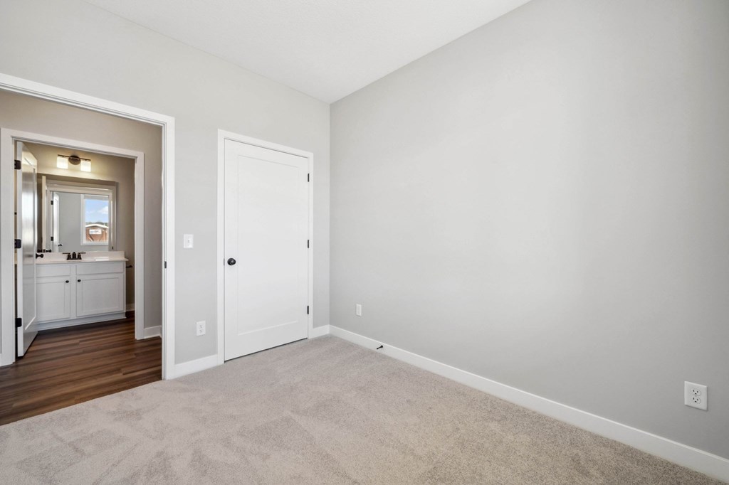 A white door is in a room with a carpet.