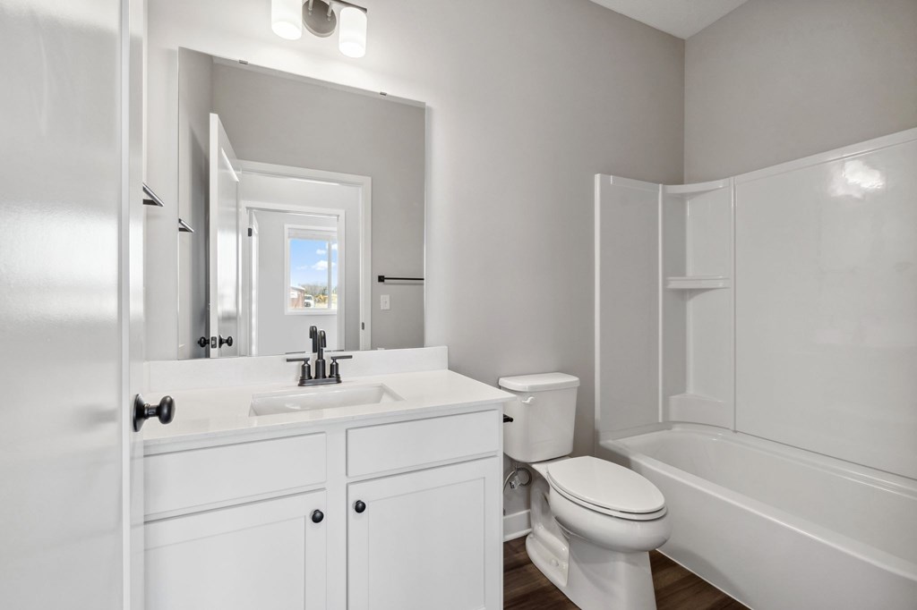 A white bathroom with a toilet, sink, and bathtub.