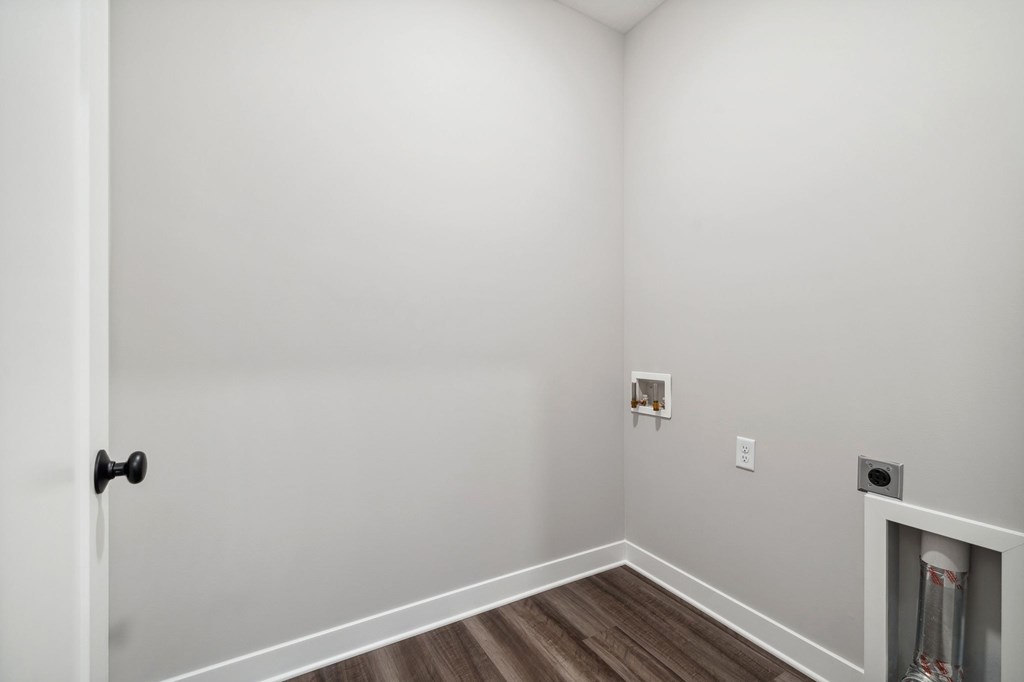 A room with a door and a light switch on the wall.