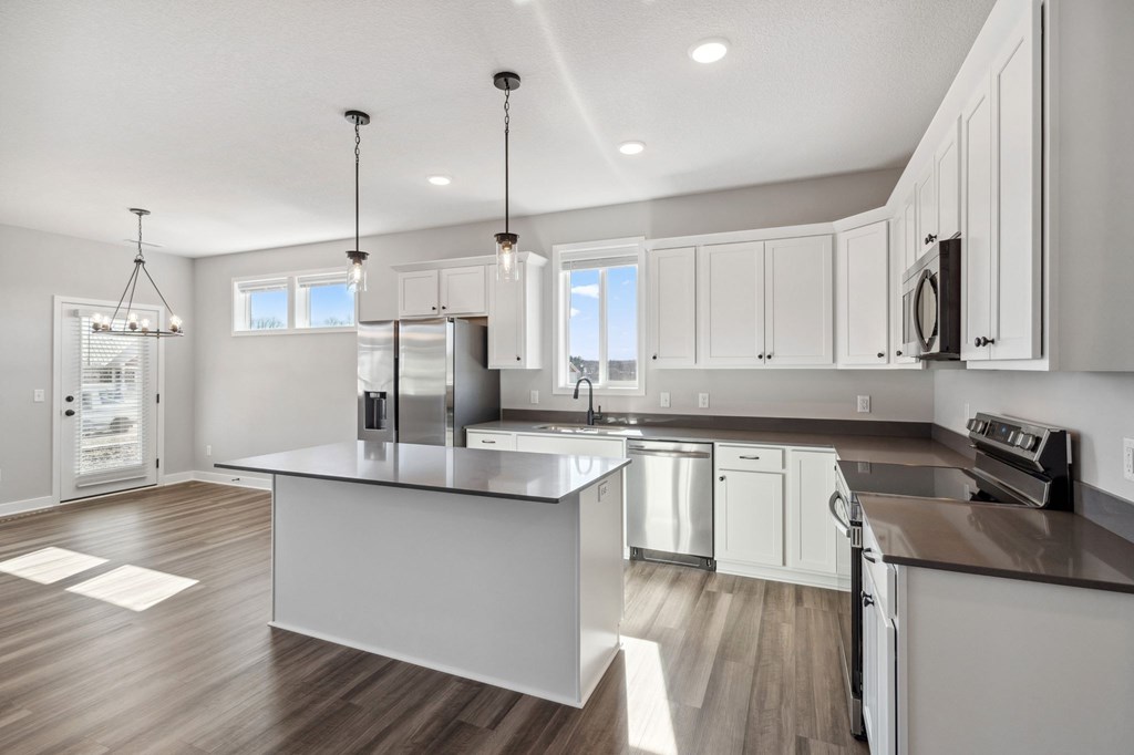 A modern kitchen with a large island and stainless steel appliances.