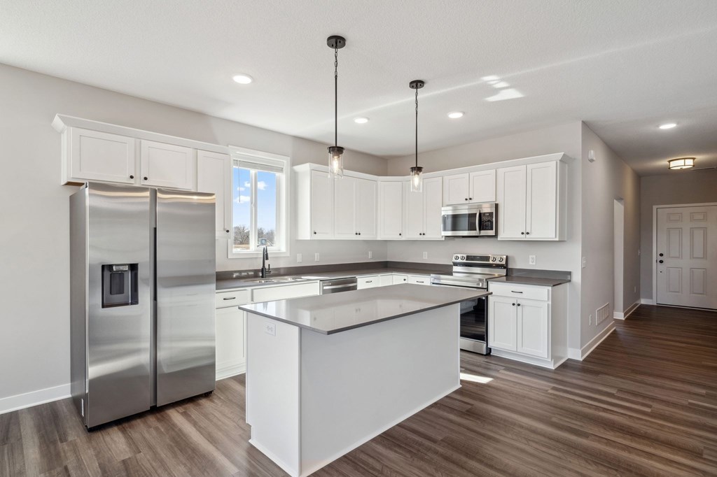 A modern kitchen with white cabinets and a central island.