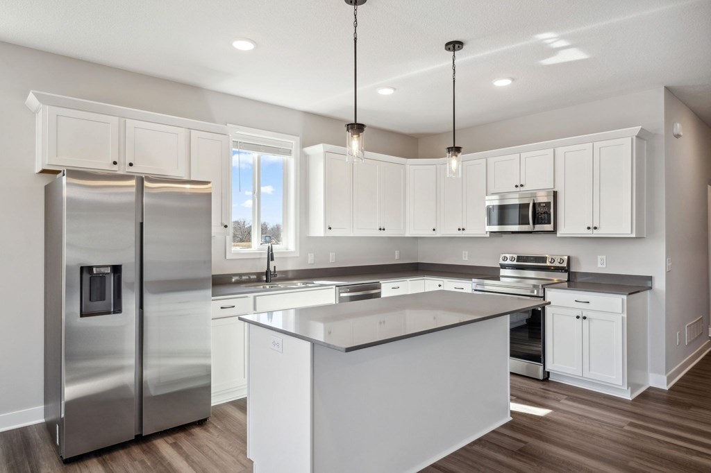A modern kitchen with a large island and stainless steel appliances.