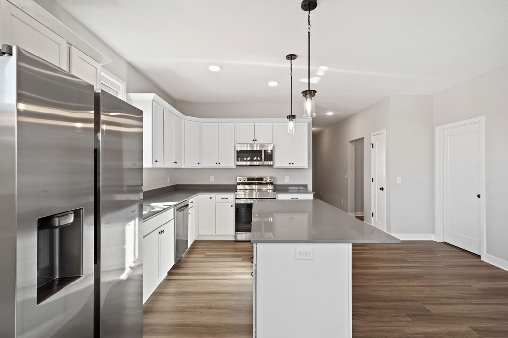 A modern kitchen with stainless steel appliances and white cabinetry.