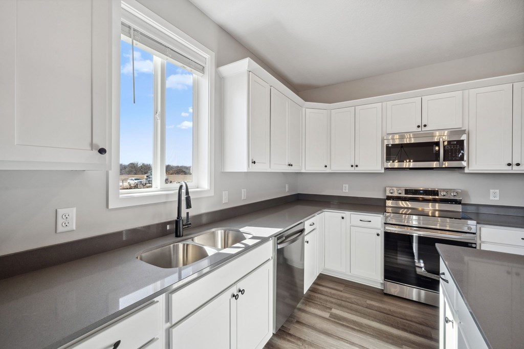 A kitchen with white cabinets and stainless steel appliances.