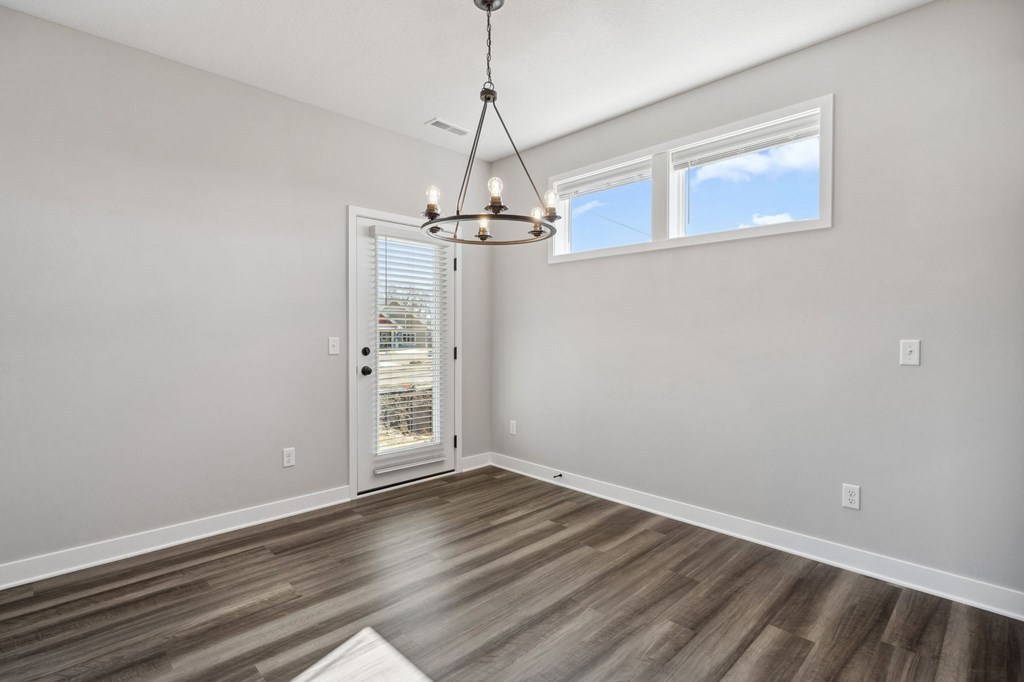 A room with a wooden floor and a chandelier.