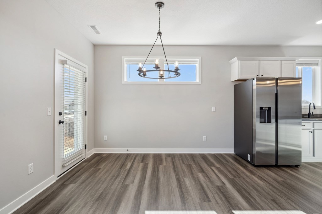 A kitchen with a refrigerator, cabinets, and a ceiling fan.