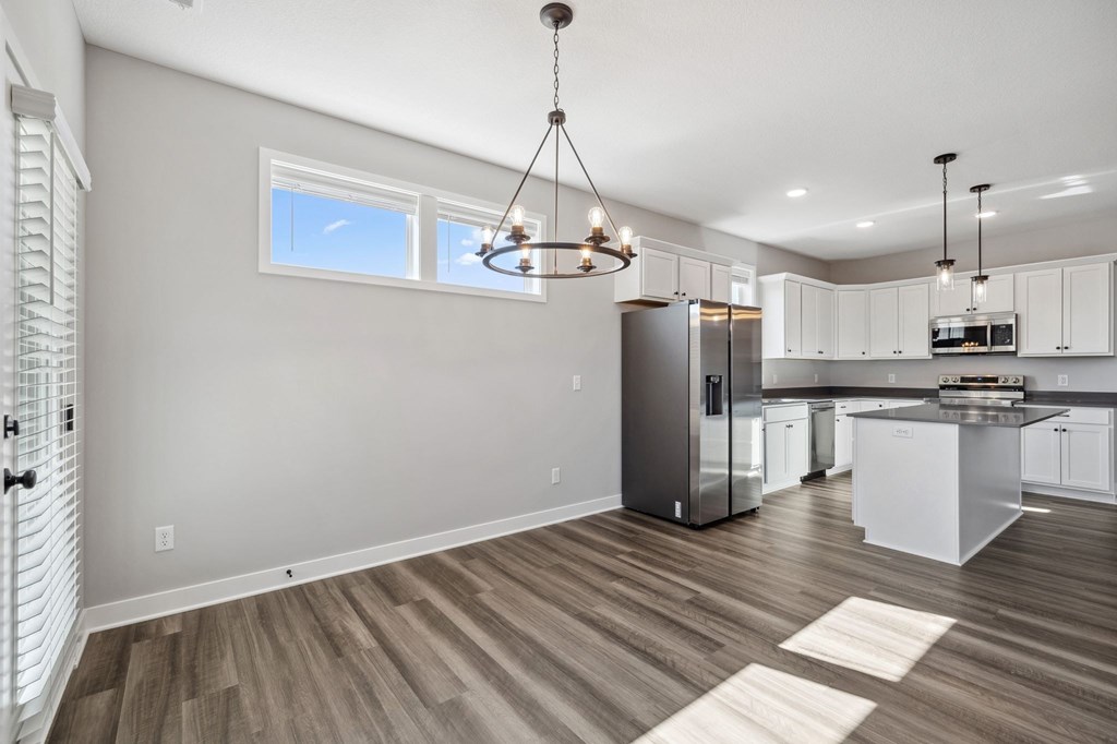 A kitchen with a refrigerator, cabinets, and a countertop.