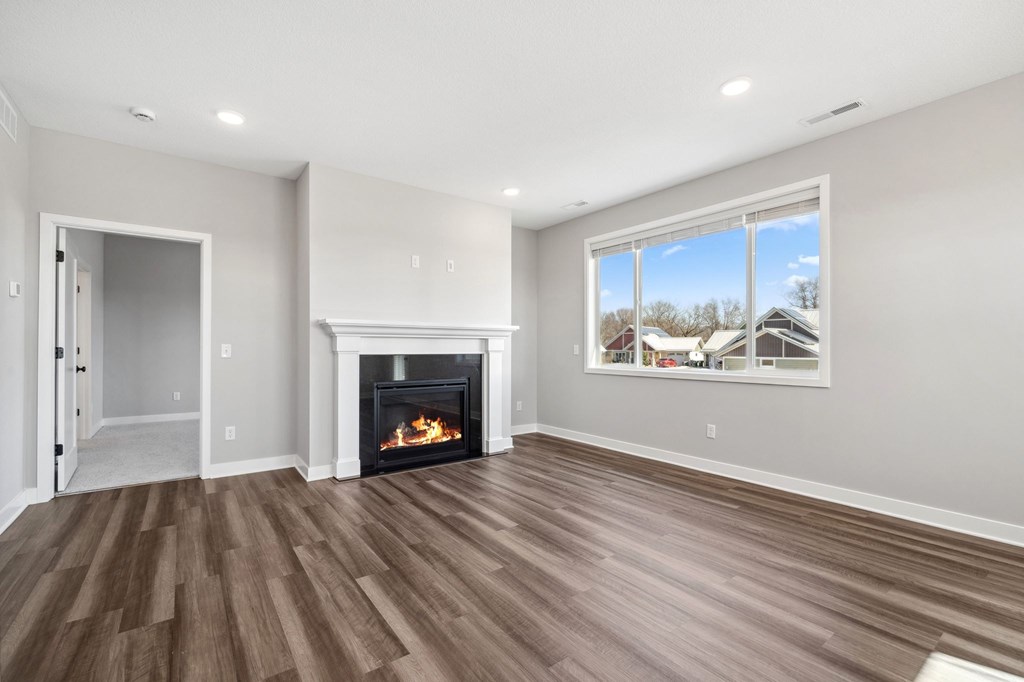 A room with a fireplace and a window overlooking a snowy landscape.