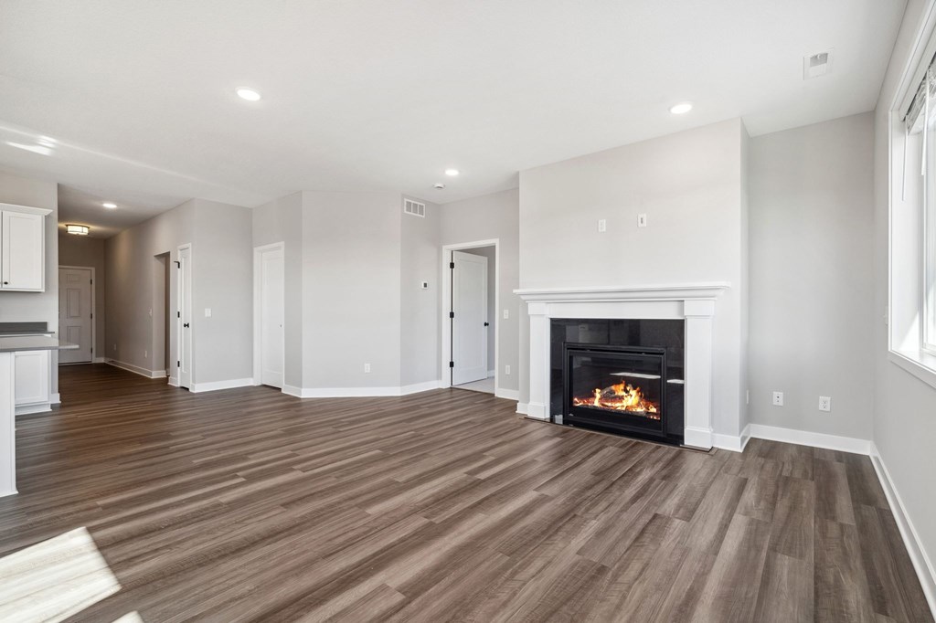 A living room with a fireplace and wood flooring.