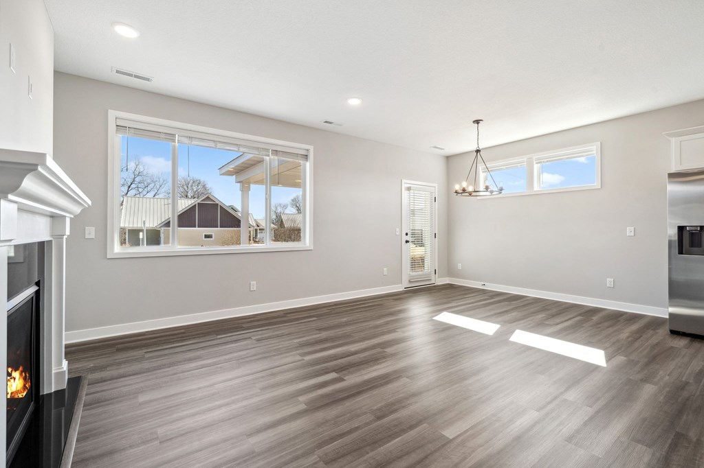 A spacious living room with a fireplace and hardwood flooring.
