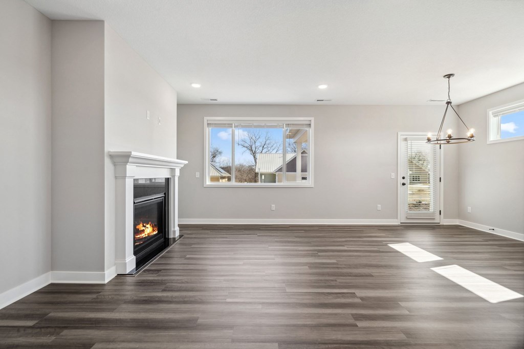 A spacious living room with a fireplace and a chandelier.
