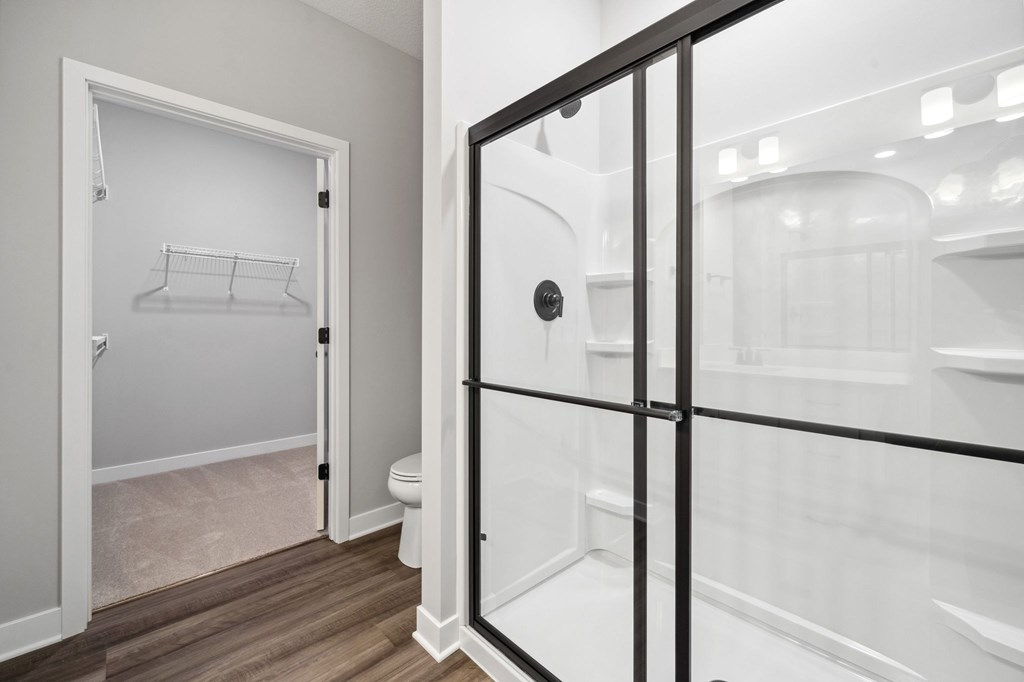 A white bathroom with a walk in shower.