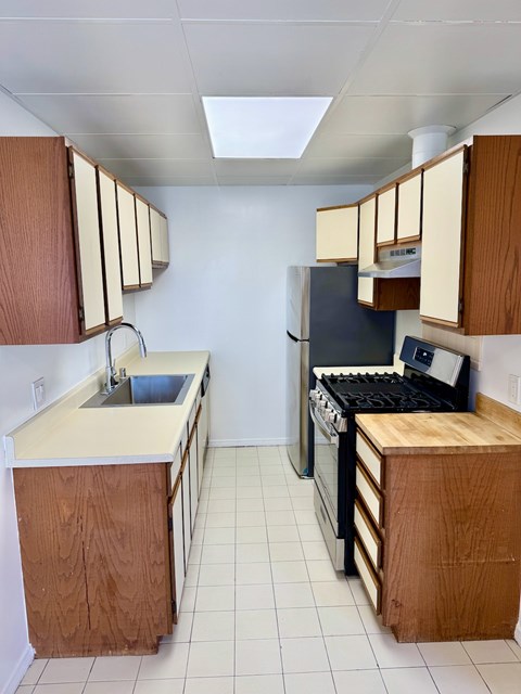 A kitchen with a sink and a stove top oven.