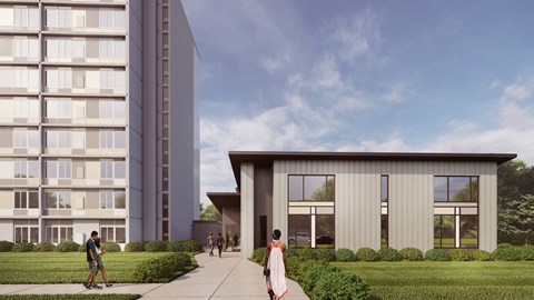 A modern building with a glass facade is adjacent to a smaller structure with a flat roof and large windows.