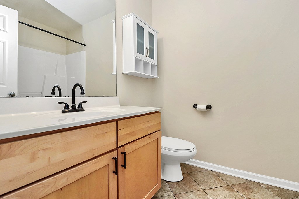A white toilet sits next to a sink in a bathroom.