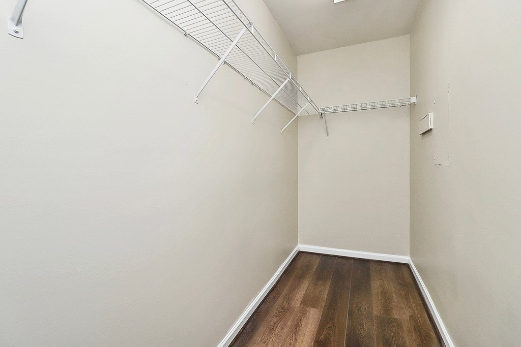 A room with a white wall and a wooden floor.