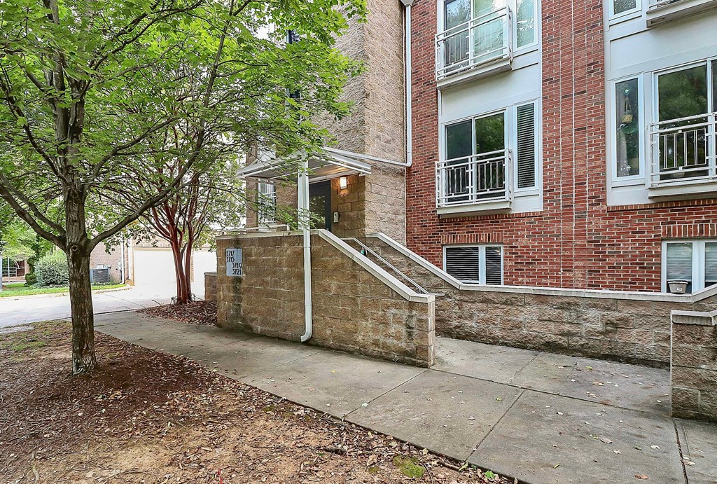 A tree is in front of a brick building.