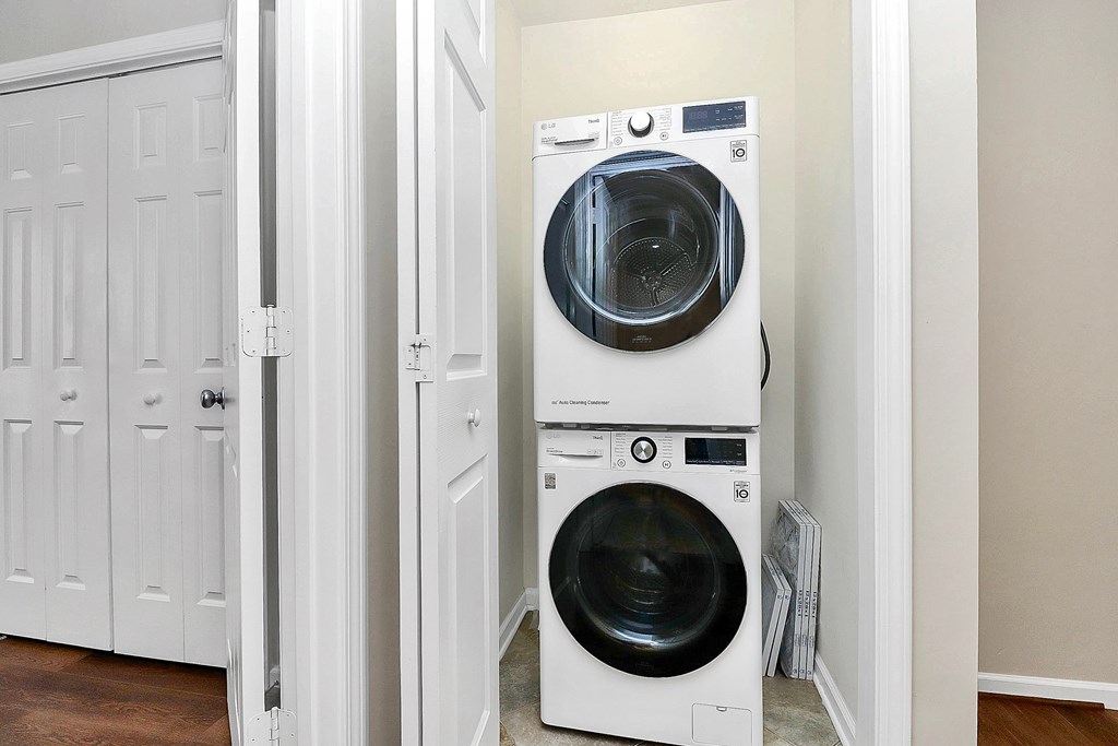 A white front load washing machine in a laundry room.