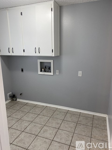 A kitchen with white cabinets and a tiled floor.