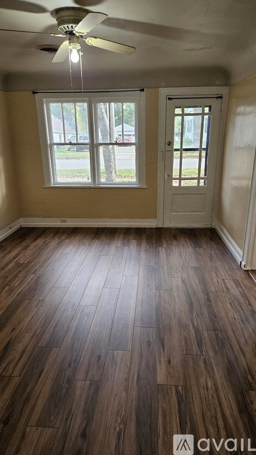 A room with wooden floors and a ceiling fan.