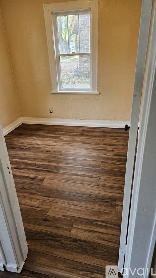 A room with wooden floors and a window.