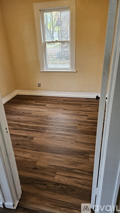 A room with wooden floors and a window.