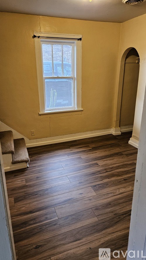 A room with wooden flooring and a window.
