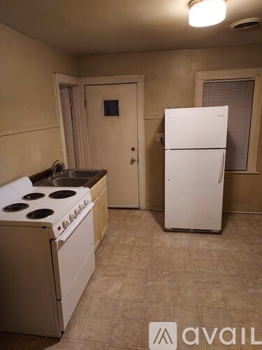 A kitchen with a white stove top oven and a white refrigerator.
