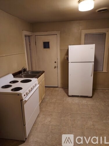 A kitchen with a white stove top oven and a white refrigerator.