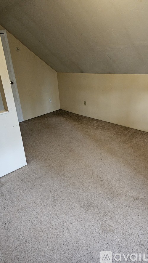 A room with a carpeted floor and a white door.