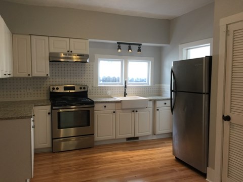 A kitchen with a black refrigerator and stove.