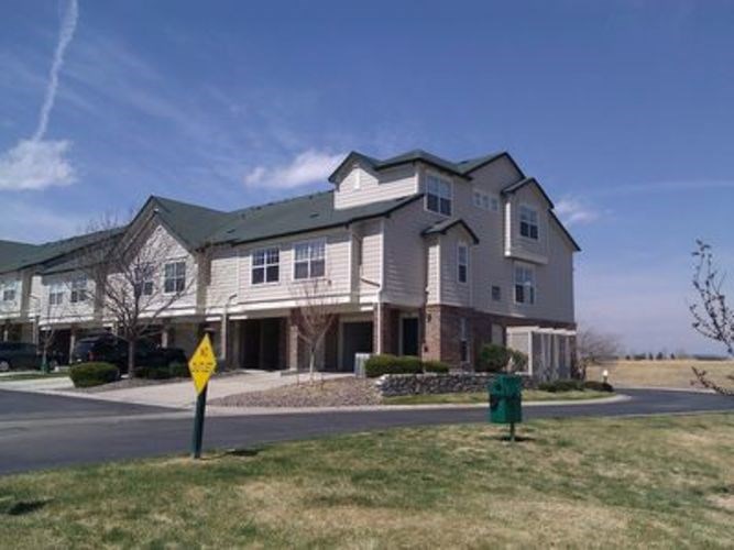 A large apartment building with a yellow sign in front of it.